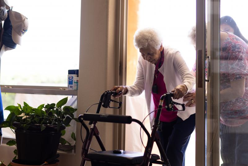woman on walker coming in from door