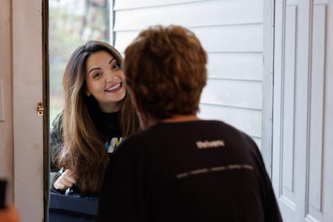 Volunteer at door with client.